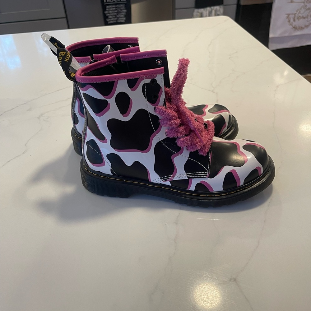 Dr. Martens Kids 1460 cow print patent leather boots in black, white, and pink